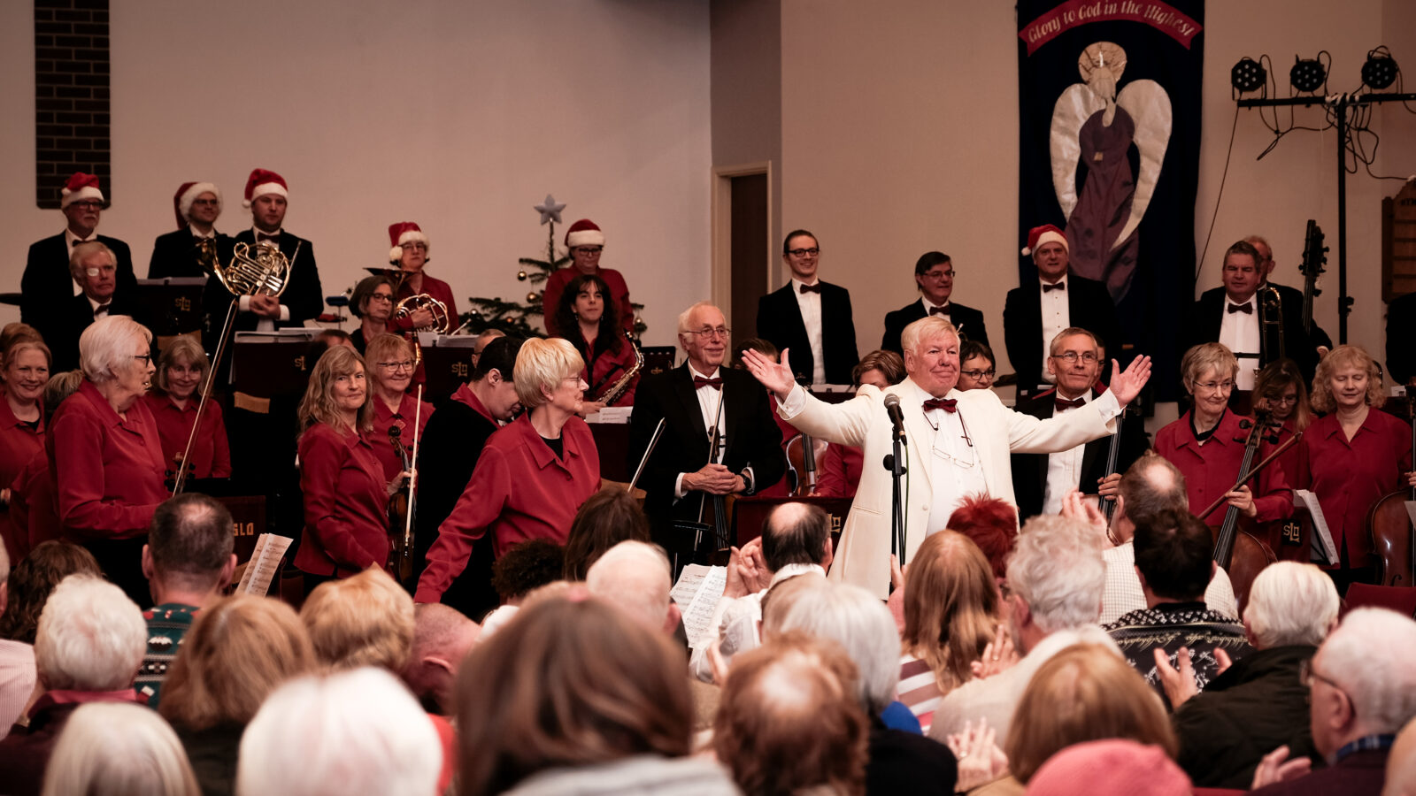 Shrewsbury Light Orchestra performing in front of a crowd, encouraging them to sing along.