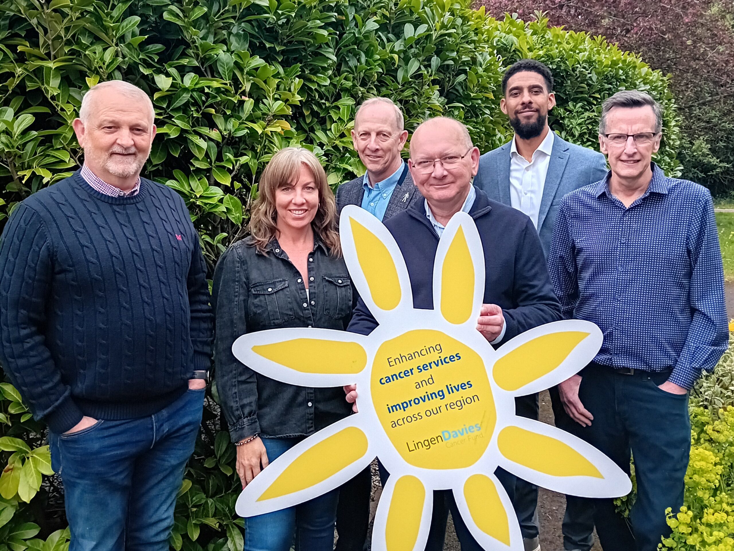 A group of people stood holding a giant sun